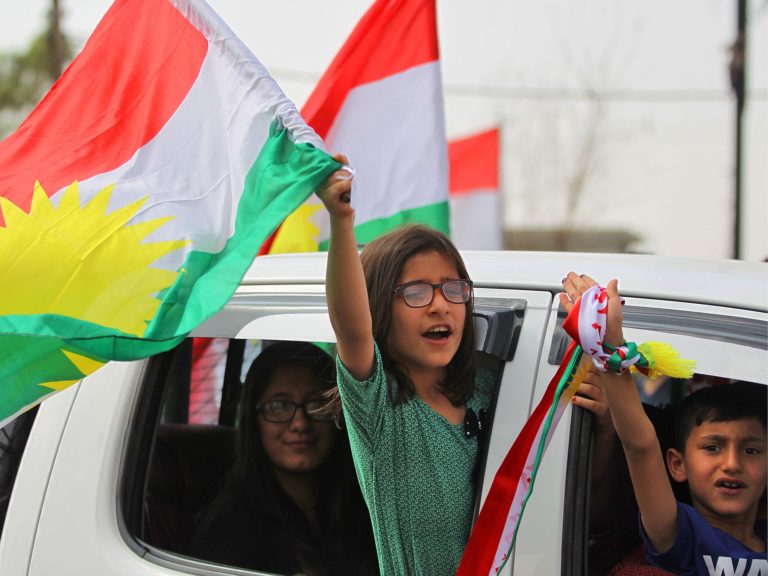 庫德族舉行獨立公投，即使沒有投票權，庫德族小朋友也興奮異常，高舉國旗遊車河。   圖：翻攝《庫德日報》