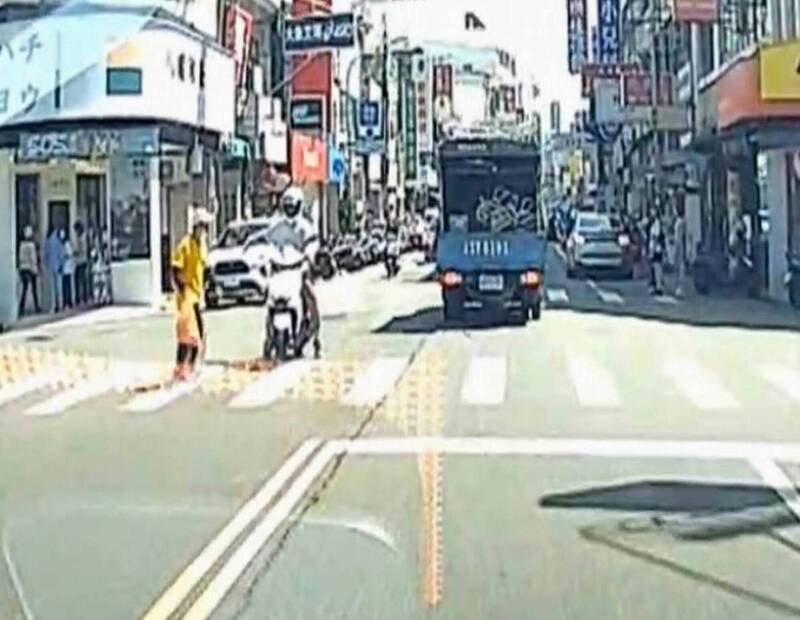 機車騎士霸氣伸手護送阿伯過馬路。   圖：民眾提供