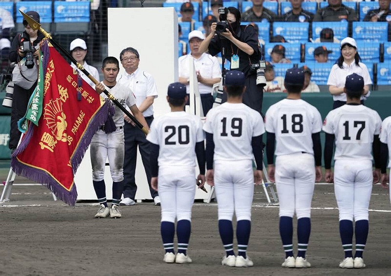 沖繩尚學隊長真喜志拓斗接過冠軍旗。(共同社)