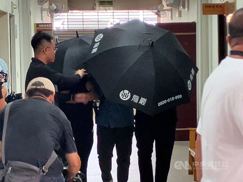 51歲羅姓男子日前在高雄市左營區住處附近遭人當街射殺，橋頭地檢署檢察官25日到市立殯儀館進行複驗，羅男家屬下午在殯葬業者撐傘陪同下配合檢方調查，面對媒體快步通過，全程不發一語。中央社記者張已亷攝  114年8月25日   