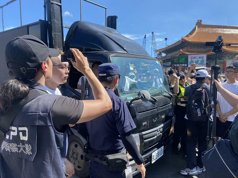 民眾黨宣傳車開抵現場,兩名警員強硬阻止前進、遭民眾以背對背擠出。 圖:林朝億/攝