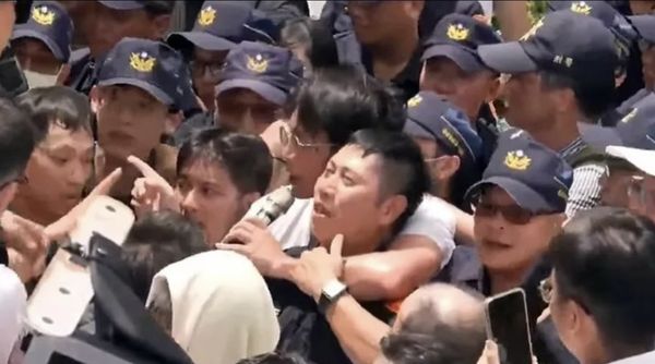 民眾黨主席黃國昌用手臂對警察繞頸勒脖，引發討論。   圖:翻攝Youtube 民眾之聲