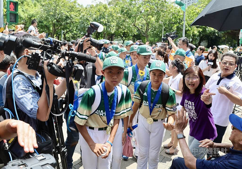 選手們在民眾夾道歡迎中出發前往台北大巨蛋。 圖:中央社記者張皓安/攝