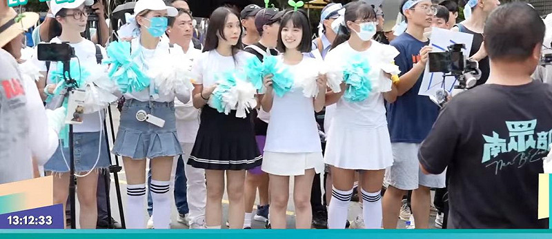 穿著短裙、手拿彩球的啦啦隊為柯文哲接風,前民眾黨發言人徐千晴(左4)也在列。 圖:截自「民眾之聲」YouTube
