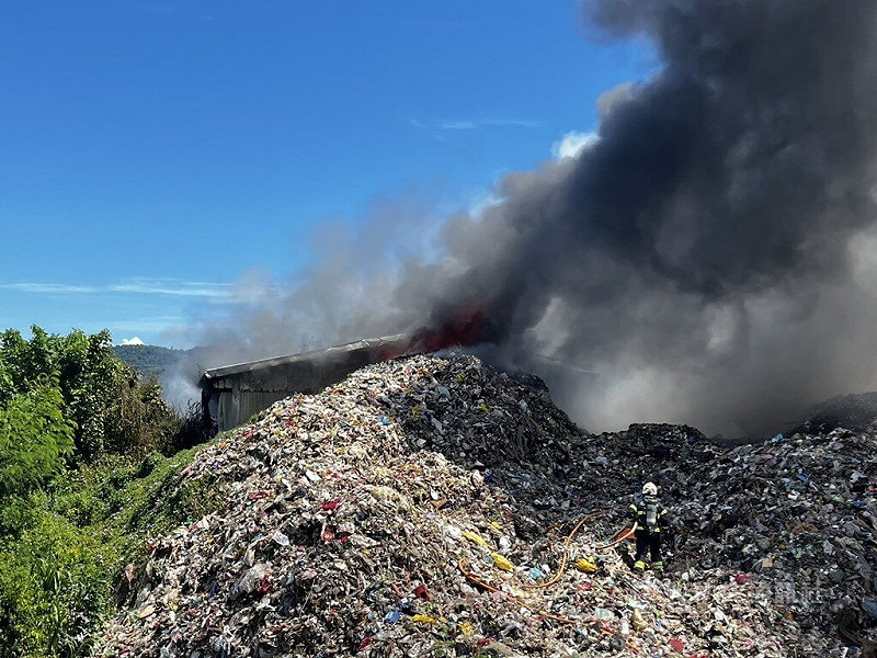 花蓮縣吉安鄉光華五街附近的垃圾掩埋場11日發生火警，黑煙直竄天際，消防人員布設水線滅火。中央社記者張祈攝　114年9月11日   