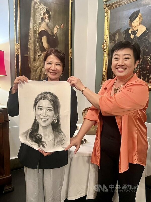 義大利僑務委員王美紅（右）贈送民進黨立委林楚茵（左）街頭藝人繪製的肖像畫。    圖/中央社