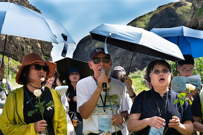 綠島「非自主缺席：第十四屆青年人權體驗營」，政治受難者陳欽生（中）、政治受難者家屬顏司音（右）、林小雲（左）領唱〈千風之歌〉向十三中隊逝者致意。   圖：國家人權博物館提供 