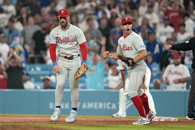 MLB費城人球星哈波（左）和羅伯森（右）15日在場中慶祝勝利。（美聯社）   