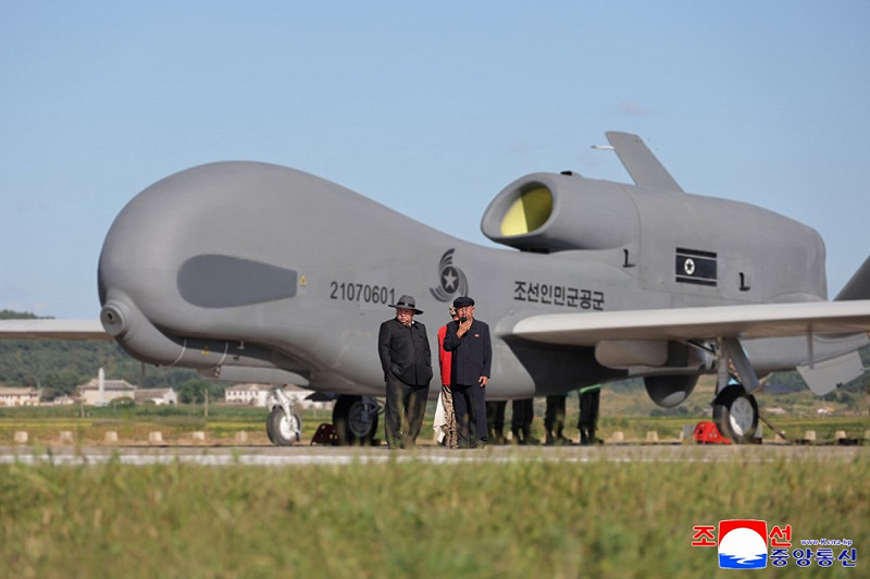 北韓領導人金正恩視導無人航空技術聯合體，背後為外型酷似美國RQ-4「全球鷹」（Global Hawk）的無人戰略偵察機。   圖：翻攝朝中社