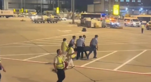 北京機場4位民警用約束帶架離在機場奔跑男子。   圖 : 翻攝自大風新聞