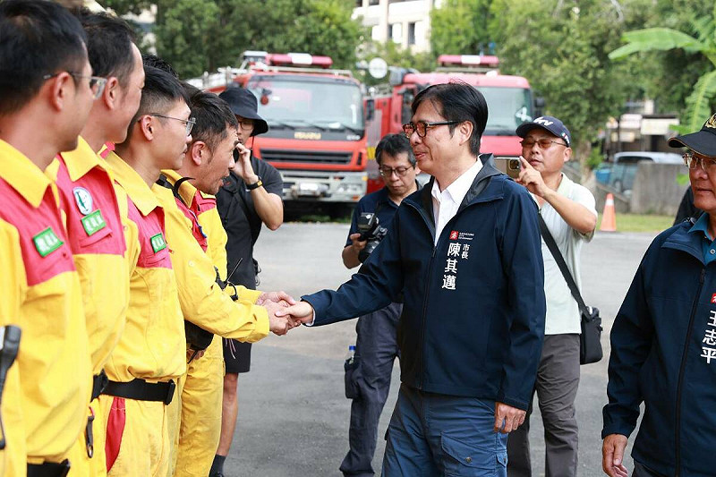 陳其邁(右三)一一與救災人員握手。   圖：高雄市消防局/提供
