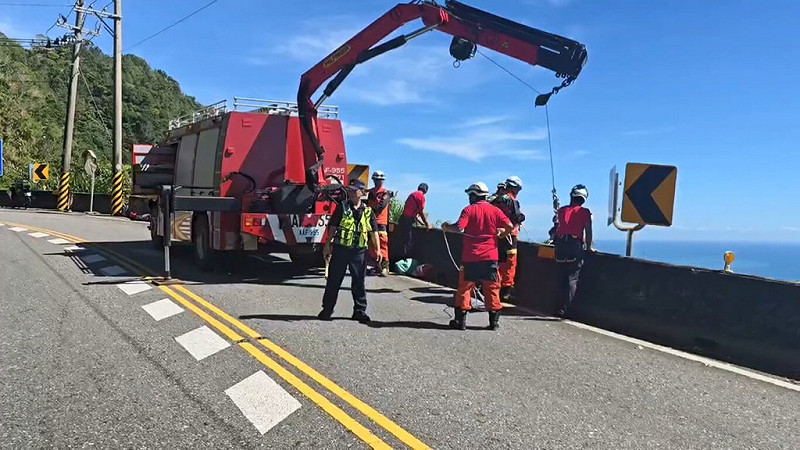 宜蘭警方30日凌晨獲報在南澳鄉台9丁線37.1公里處，疑有機車自撞護欄，經出動無人機搜索，在海側懸崖距路面約80公尺處草叢發現一具男性遺體，正設法以吊掛方式運至路面。（讀者提供）中央社記者王朝鈺傳真  114年9月30日   