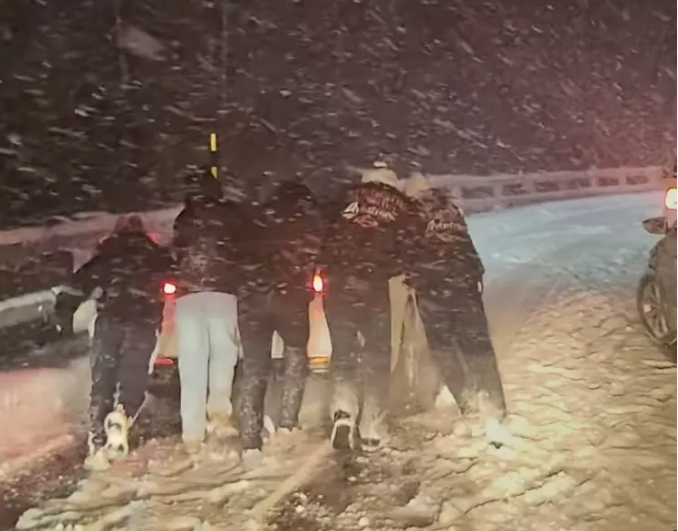  受困新疆喀納斯的民眾在大雪中推車。 圖 : 翻攝自上游新聞 