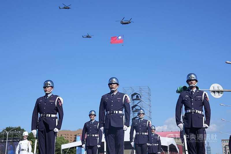 114年國慶大會預演6日在總統府前登場，進行至國歌領唱儀式時，空中2架UH-60M黑鷹直升機伴飛1架吊掛巨幅國旗的CH-47SD契努克運輸直升機，共同飛越凱達格蘭大道上空。   圖：中央社提供
