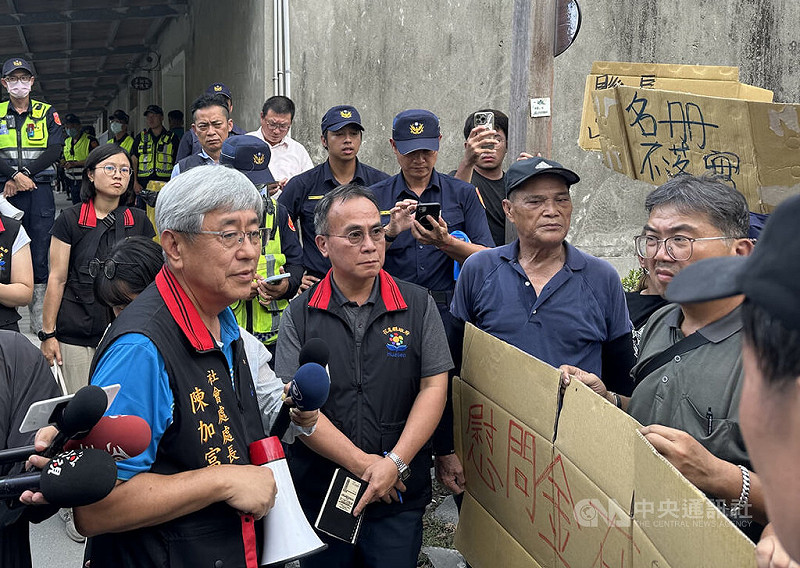 花蓮縣政府發給堰塞湖溢流受災戶的慰助金未納入大進村、大全村、南富村，村民6日到縣府前進指揮所外抗議，縣府社會處長陳加富（前左）出面表示，村民有損失訴求可匯集起來，若認為因救災造成生活影響，也可以寫成陳情案，縣府受理後就會處理。   圖：中央社提供