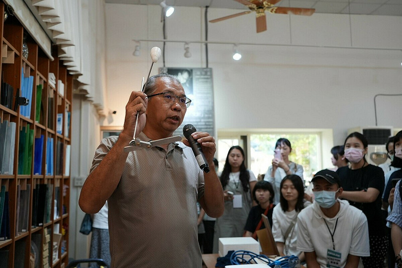 陳宗漢(左一)向參訪團隊介紹玻璃燒製工具與製程工藝。   圖：高雄市青年局/提供