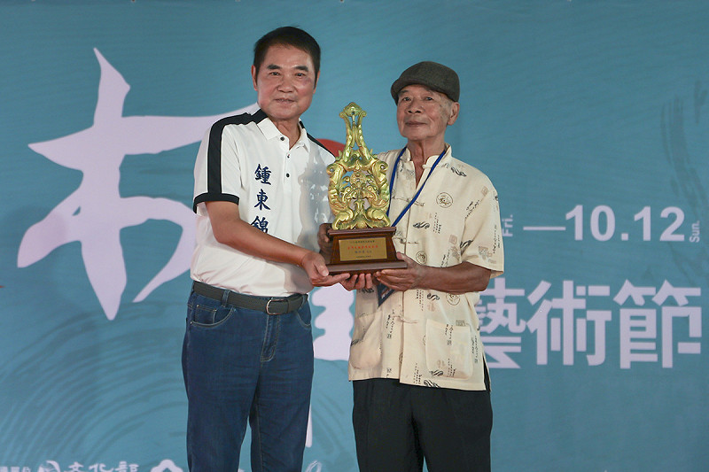 苗栗縣長鍾東錦頒獎給為今年台灣木雕薪傳成就獎得主黃弘彥。   圖：苗栗縣政府／提供