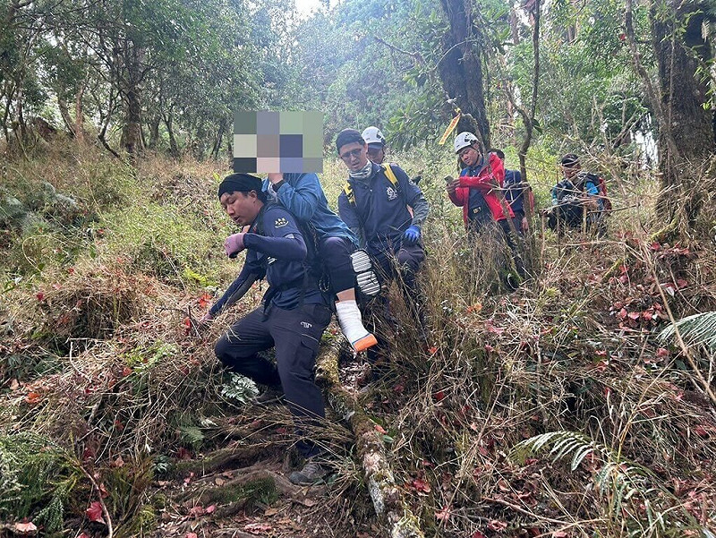 台南市一對夫妻11日至阿里山攀登路況較陡峭的兒玉山路線，不料妻子不慎摔倒導致左腳踝疑脫臼，嘉義消防人員獲報上山援救，以背架將人揹負接駁下山。（嘉義縣消防局提供）中央社記者黃國芳傳真  114年10月11日   