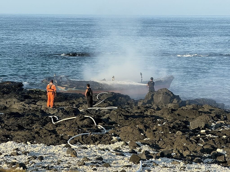 澎湖一艘泊靠吉貝垃圾場北方岸際疑似廢棄漁船13日起火燃燒，吉貝消防與岸巡等單位馳援，現場部署水線，並延伸4條水帶出水，順利撲滅火勢。（澎湖消防局提供） 中央社　114年10月13日   