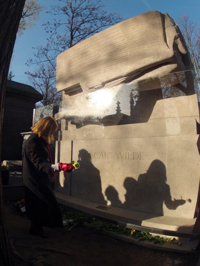 一名女子在剛剛完成玻璃框的王爾德墓前獻花。圖片來源：達志影像/路透社。   