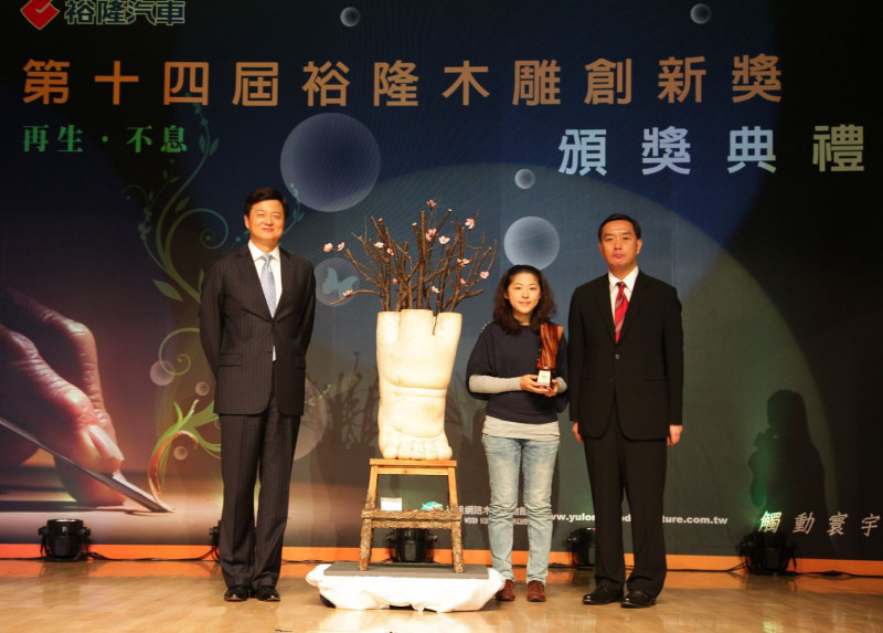 23歲的年輕創作者黃品彤（中），勇奪「裕隆木雕創新獎」首獎，在頒獎典禮上與台北縣長周錫瑋、裕隆汽車董事長嚴凱泰合影。圖片來源：裕隆公司提供   