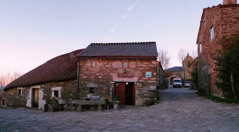 朝聖之路上進入Galicia的第一個村莊OCebreiro，就可看見傳統塞爾特的圓形茅草屋（Palloza）。餐館前的石桌椅就是當天大家把酒言歡的地方。圖：釀出版提供   