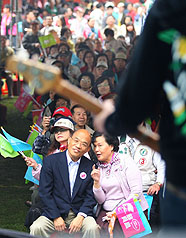 民進黨台北市長參選人蘇貞昌（前左）30日與妻子詹秀齡（前右）出席北投超越總部成立大會，在台下聆聽董事長樂團的演出時，偶爾也跟著音樂高歌。圖片來源：中央社   