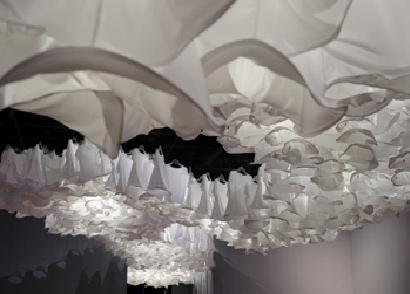 徐薇蕙的「綻」，1千件白色T恤由屋頂上方懸吊下來，高低錯落，就像是開滿一整個天花板的花朵，創造出美麗的視覺奇觀。圖片來源：高雄駁二藝術特區   
