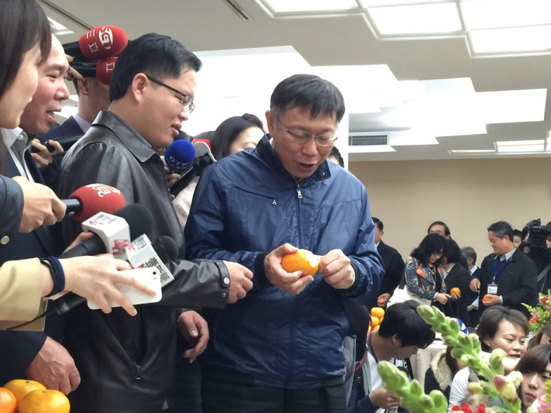 台北市長柯文哲今(24)日上午前往台北市議會新春團拜，團拜後，柯在餐桌上拿起象徵大吉大利的橘子剝皮，接著一口吃下。圖：劉奕霆/攝   
