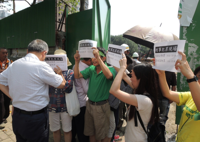 潘翰疆與10多位的護樹志工，今日高舉「刑事犯罪現場」的標語，向江翠國中總務主任（左一）質疑移樹的程序違法。圖：陳冠廷/攝   