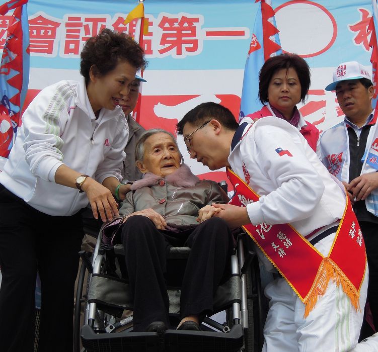 林鴻池高齡93歲的母親林粉（中）除替林鴻池披上選舉的肩帶外，並親自向民眾懇託，請大家一定要支持林鴻池。圖片：陳冠廷/攝   