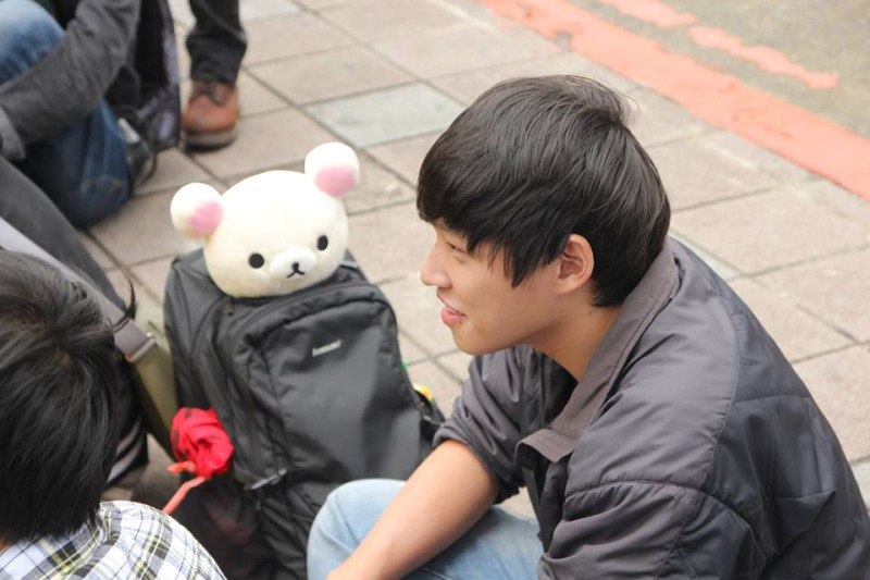 圖為學運領袖陳為廷去年4月3日參加反媒體巨獸青年聯盟的活動，背包裡放著拉拉熊布偶，坐在立法院大門口外開會的情形。圖：林雨佑/攝   