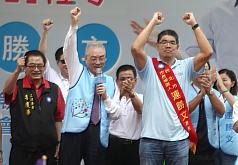 國民黨台北市長參選人連勝文（前右）27日舉行競選總部成立大會，副總統吳敦義（前左）到場幫連勝文披肩帶，高喊加油當選。圖：中央社   