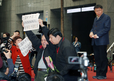 台北市長柯文哲「進口外籍新娘」說引發爭議，8日下午出席「幸福女人調感恩音樂會」時，有民眾現場舉牌抗議。圖：中央社   