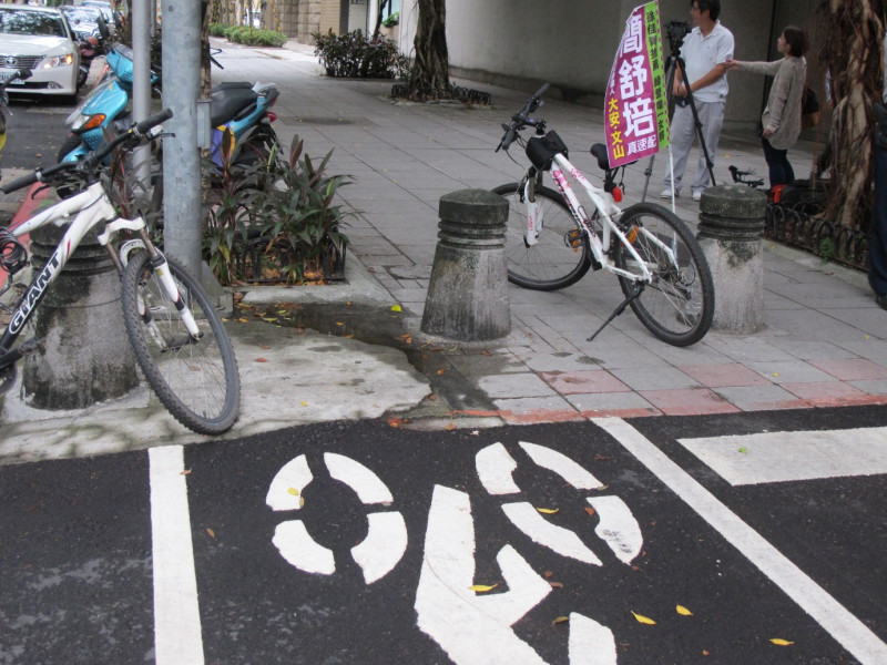 台北市仁愛路三段118巷路口，看得到自行車穿越道設計嚴重瑕疵，居然是直接撞上路燈桿與行道樹的。圖：林朝億/攝影   
