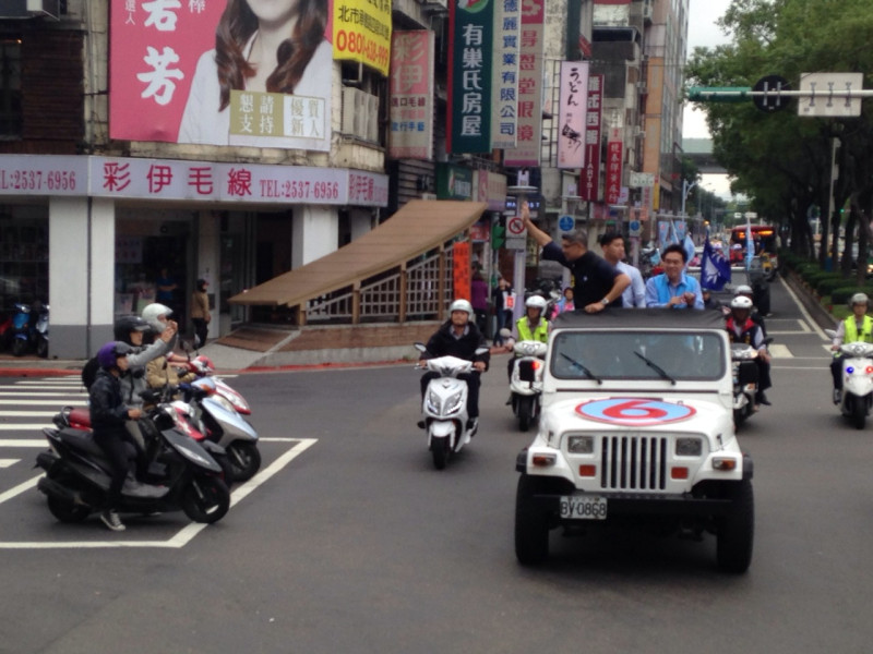 連勝文今(27)日在台北市長郝龍斌的陪同下，進行8小時車隊掃街活動，一旁騎機車的民眾則拿出手機拍照。圖：劉奕霆/攝   