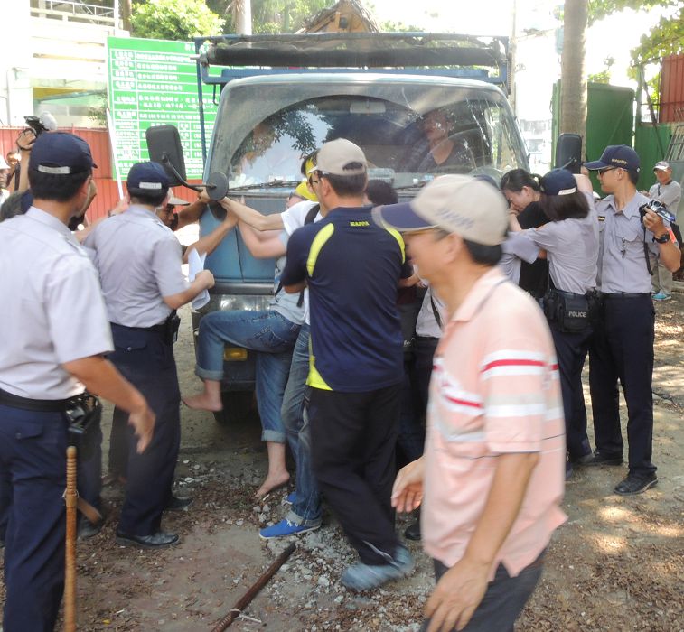 江翠護樹志工隊的退休老師、居民、校友、聲援網友,以躺在地上、鐵鍊綁手、抱樹或爬到樹上等,肉身擋車的方式強力阻擋機具進入。圖:陳冠廷/攝