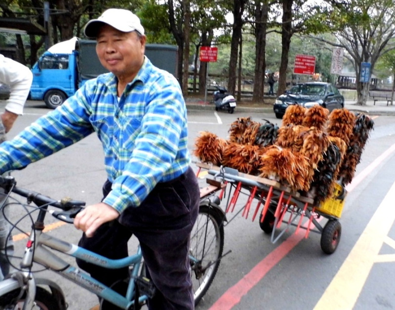 在新竹市騎自行車叫賣雞毛撢子的黃傳名，轉眼靠這一行生活已經30年了。圖：陳權欣/攝   