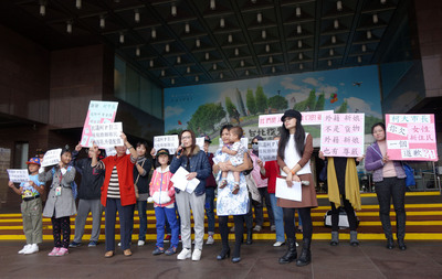 台北市長柯文哲「進口外籍新娘」說引發爭議，台北市新移民女性關懷協會的10幾名外籍配偶成員，8日帶著孩子前往北市府門口抗議。圖：中央社   