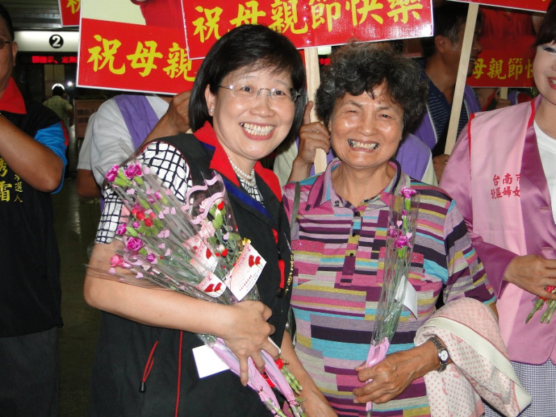 國民黨台南市長參選人黃秀霜（左）到台南火車站致贈來往旅客每人一束康乃馨，祝大家母親節快樂，受到民眾熱烈歡迎。圖：黃博郎/攝   