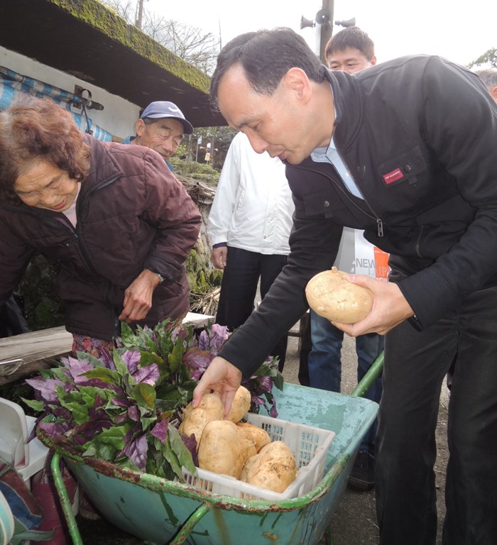 新北市長朱立倫自掏腰包買2袋蔬菜，並表示因為這裡的蔬菜都是有機種植，不但好吃也非常健康。圖：陳冠廷/攝   