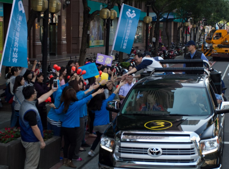 國國民黨新北市長候選人朱立倫今（21）日上午站上黑色的貨卡主戰車，車隊沿著板橋主要的道路前進，熱情民眾還爭相和朱立倫握手，氣氛熱烈。圖：陳冠廷/攝   