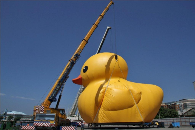 由荷蘭籍藝術家霍夫曼設計黃色小鴨，台灣首站於高雄展出，下午4時黃色小鴨從駁二藝術特區鳴笛啟航，在迎賓船水柱歡迎下緩緩游進光榮碼頭。圖：高雄市政府提供   