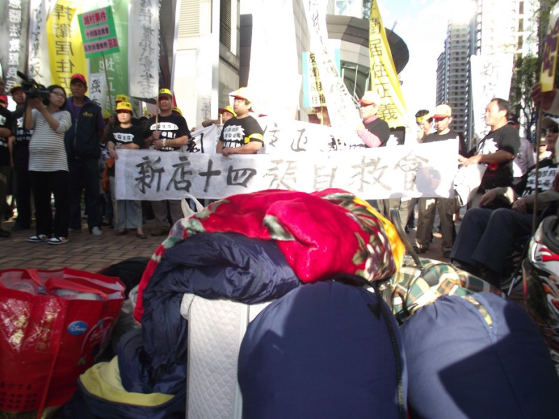 十四張自救會的抗議民眾，也把棉被置放在抗議現場，以凸顯不滿市政府未安置就迫遷的作法。圖片：陳冠廷/攝   