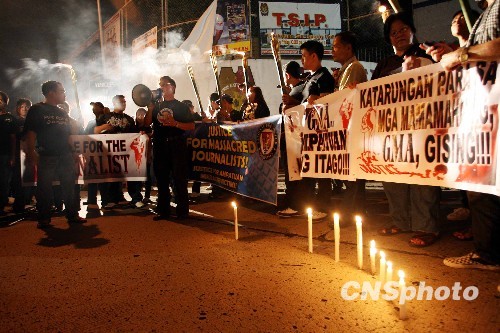 菲律賓全國記者協會24日晚穿黑衣、持火把，集聚馬尼拉警察總部，要求政府給受害的記者一個公道。（圖：中新網）   