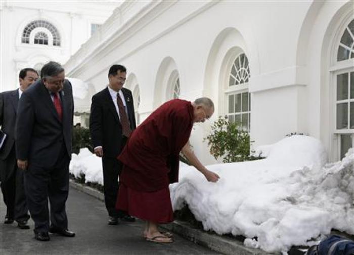 達賴喇嘛18日在美國白宮與美國總統歐巴馬會談，經過白宮戶外，他彎腰用手摸白宮的積雪。
圖片來源:達志影像/路透社   
