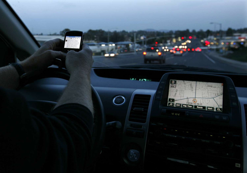汽車駕駛一邊開車、一邊以手機傳簡訊。來源：達志影像/路透社   