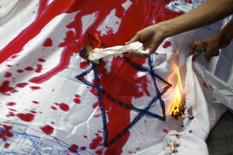 在反以色列的遊行中，瑞內瑞拉學生在白布上染了紅色油漆，並引火焚燒象徵以色列圖騰的猶太之星。圖片來源：達志影像／路透社   