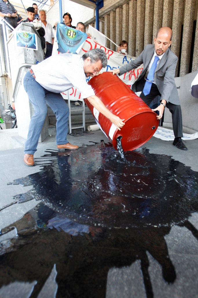 美國環保人士以倒石油的方式抗議政府處理墨西哥灣漏油不力。
圖片來源:達志影像/美聯社   