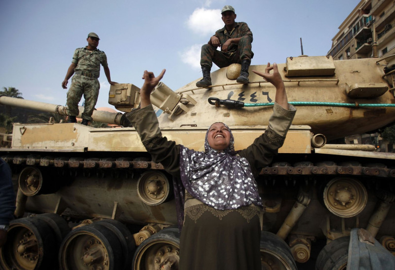 一名埃及婦女站在坦克車前，歡慶總統穆巴拉克下台。圖片來源：達志影像/路透社。   